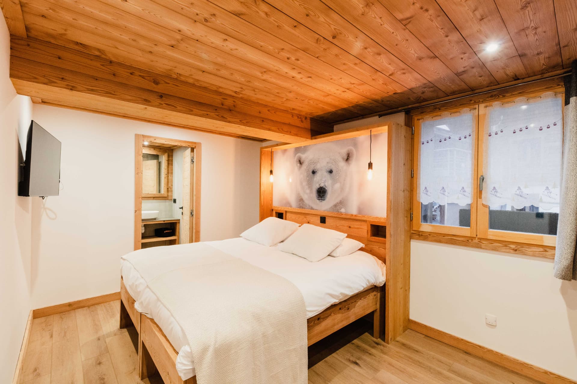 Chambre double avec tête de lit ours blanc et salle de bains attenante