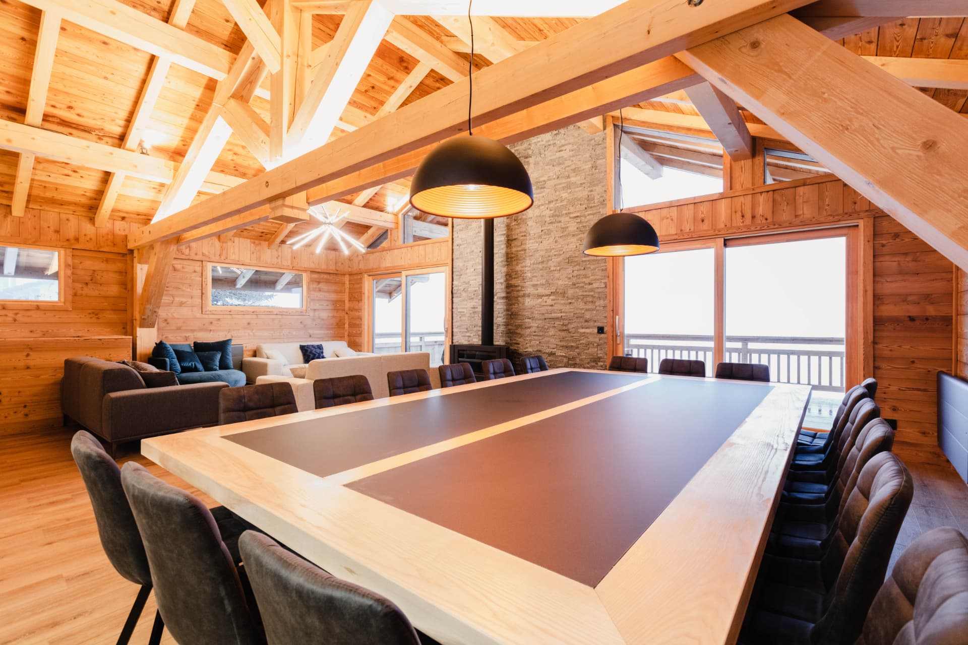 Grande table de salle à manger sous la charpente apparente du chalet