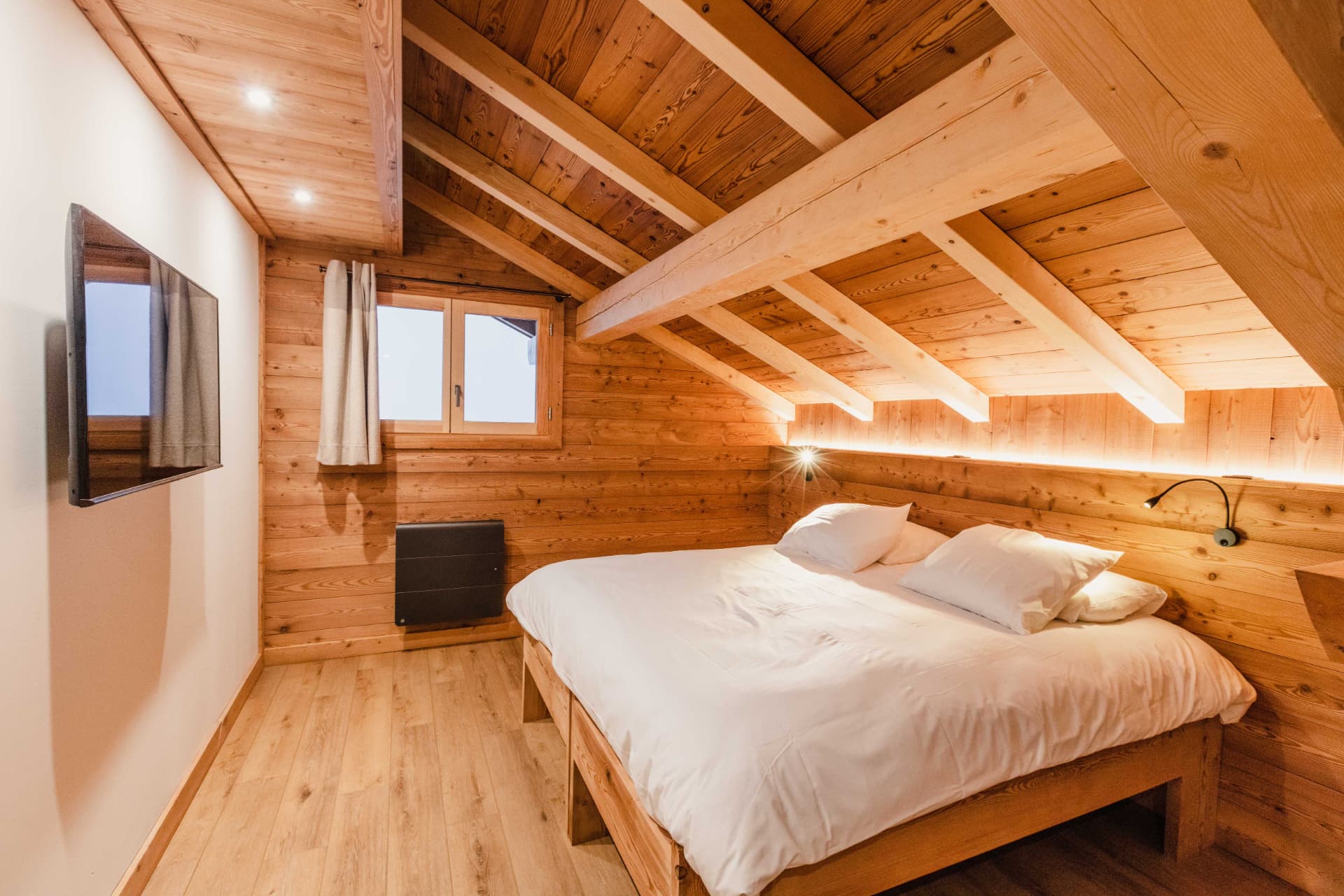 Chambre mansardée sous charpente avec éclairage indirect