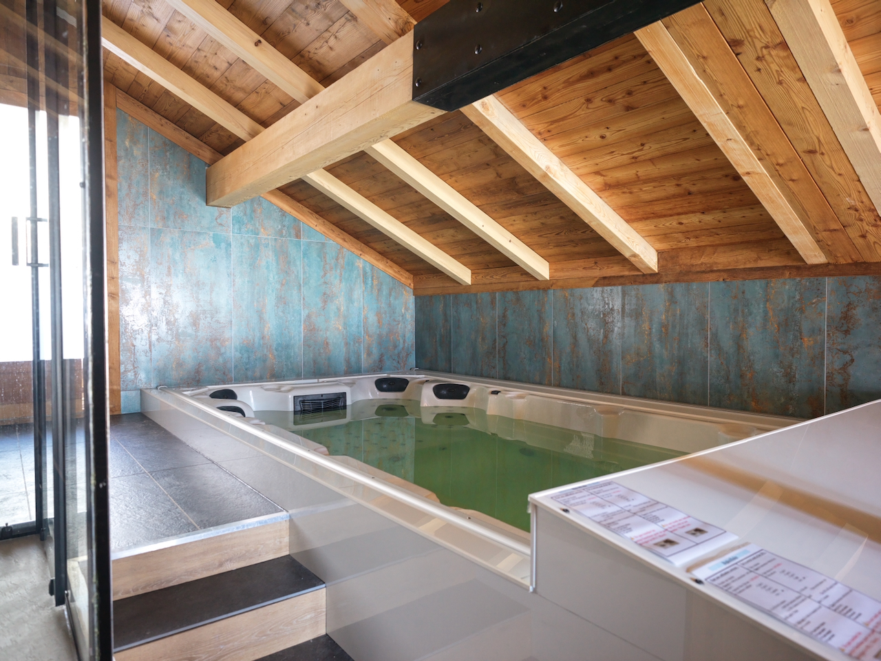 Jacuzzi et espace bien-être du chalet avec poutres en bois