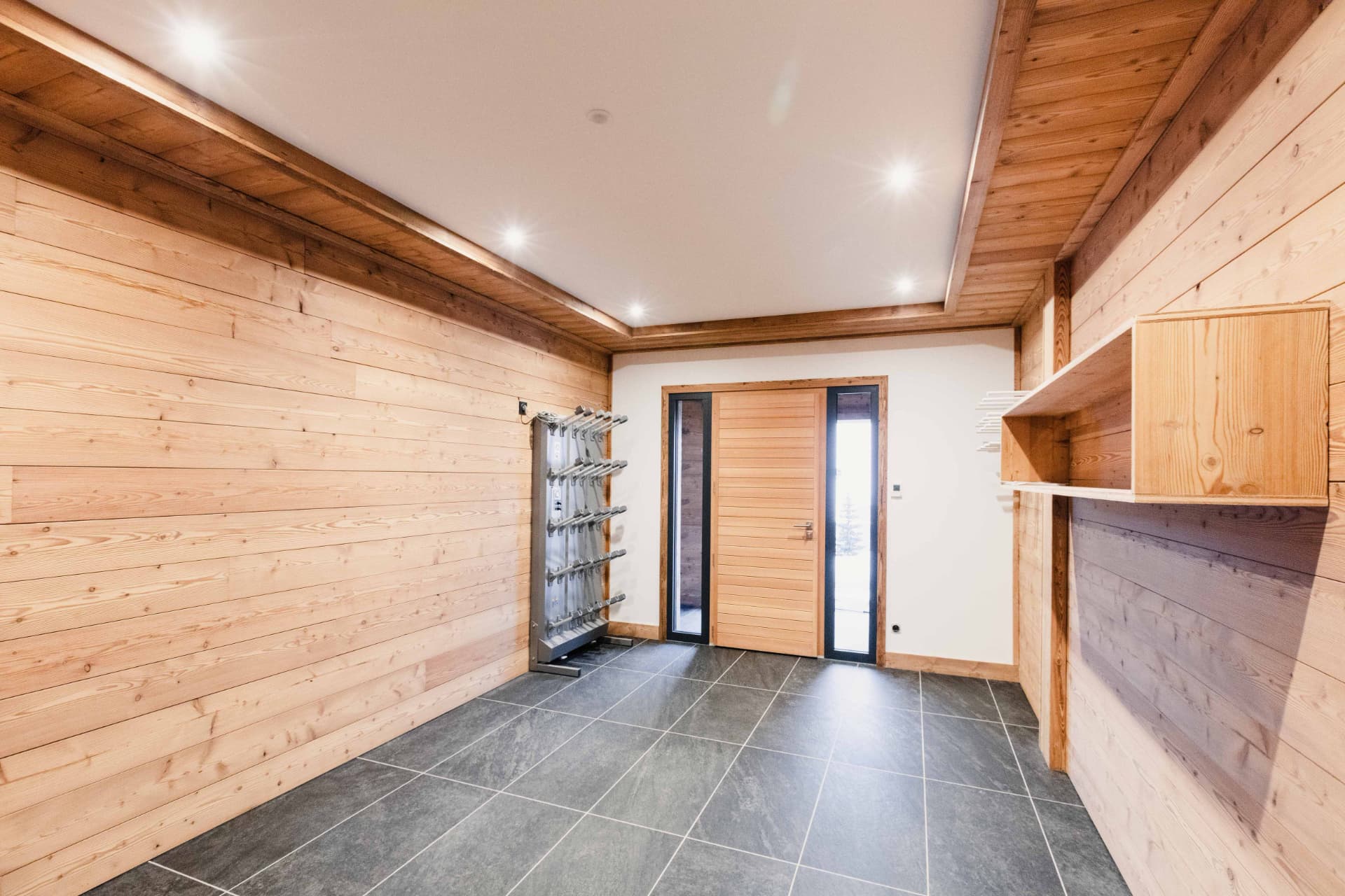 Ski room du chalet avec sèche-chaussures et rangements en vieux bois