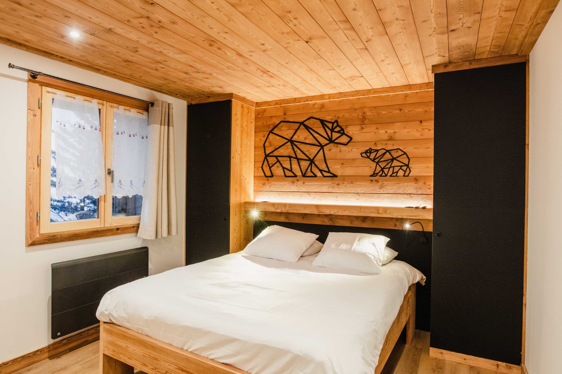 Chambre double avec ours géométriques en métal noir au-dessus du lit