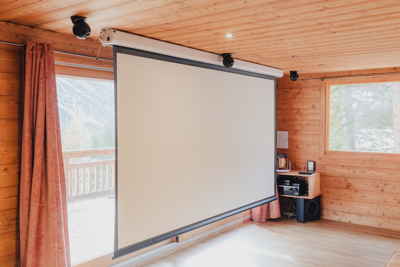 Salle de cinéma du chalet avec écran de projection